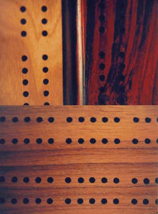 a close up of the holes on several cribbage boards