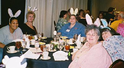 Image: People wearing bunny ears at a table.