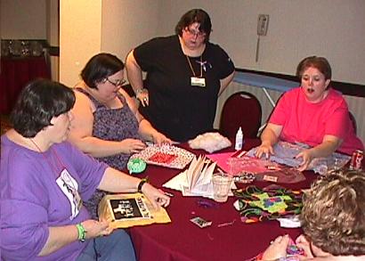 Image: People at table working on quilt squares.